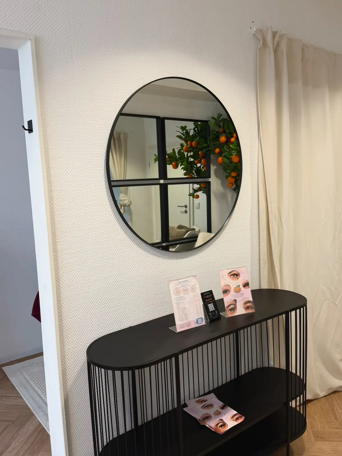 Runder Spiegel über schwarzer Konsole im Studio